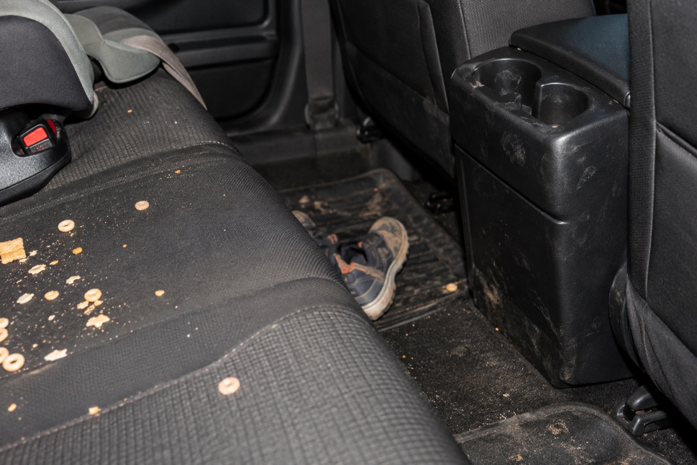 Crumbs and everyday mess in a family vehicle back seat